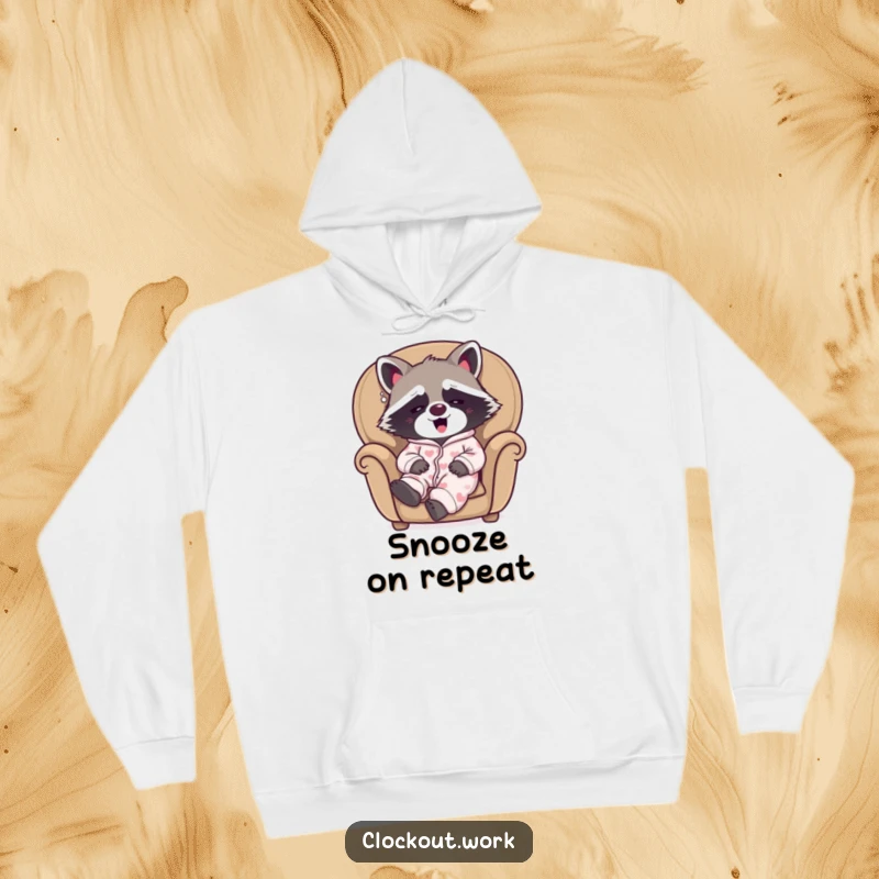 Funny hoodie featuring a sleepy raccoon in pajamas, happily yawning while nestled in a cozy armchair.